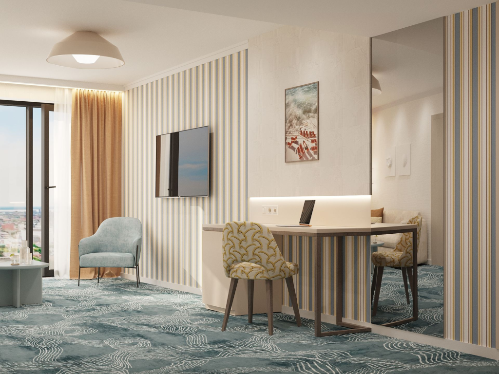 Nowoczesna strefa wypoczynkowo-biurowa apartamentu Linea Mare Kołobrzeg z biurkiem, lustrem, telewizorem i fotelem przy dużym oknie.