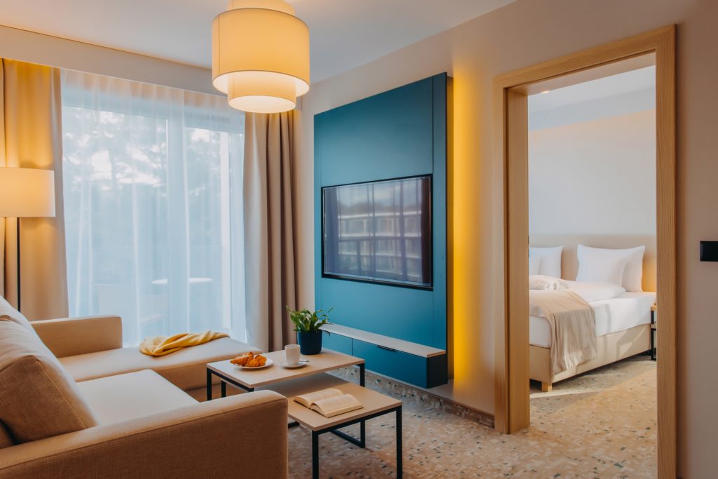 Nowoczesne apartamenty hotelowe w Linea Mare Pobierowo – salon z telewizorem i widokiem na sypialnię