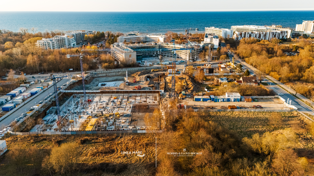 Budowa Linea Mare w Kołobrzegu w kwietniu 2026 – widok z góry na fundamenty, żurawie i teren inwestycji nad morzem